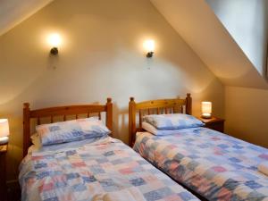 two beds sitting next to each other in a room at Kirsty Cottage in Moffat