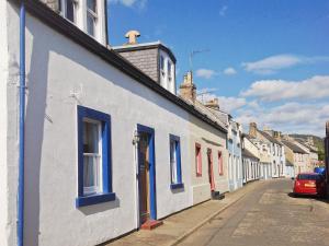 a row of white and blue houses on a street at Kirsty Cottage in Moffat