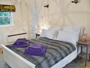 a bedroom with a bed with purple towels on it at Tower Cottage - Mvw in Belsay