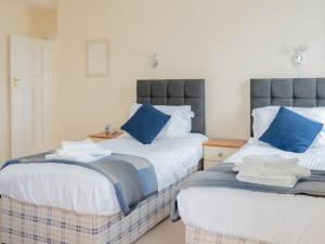 ブリクサムにあるCliff Cottageのベッドルーム1室(青い枕のベッド2台付)