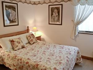 a bedroom with a bed and two pictures on the wall at Pheasant Roost in Swanton Morley