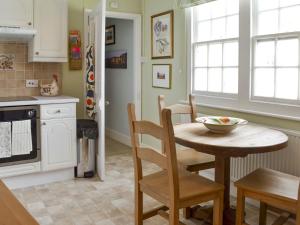 a kitchen with a table and chairs in a kitchen at Pax in St Margarets at Cliff