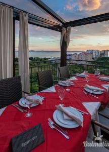 einen Tisch mit einem roten Tischtuch und Weingläsern in der Unterkunft Adela Apartments Žnjan Split in Split
