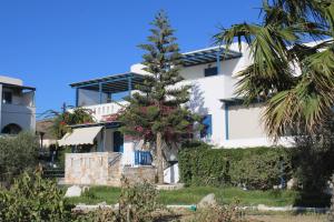 een palmboom voor een wit gebouw bij Crystal Naxos 1 Studios at Mikri Vigla in Mikri Vigla