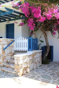 a white fence and a tree with pink flowers at Crystal Naxos 1 Studios at Mikri Vigla in Mikri Vigla