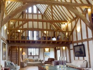 a large room with a wooden ceiling with beams at Low Farm Barn in Laxfield