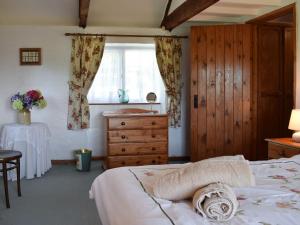 a bedroom with a bed and a dresser and a window at Cych Cottage in Capel-Ifan
