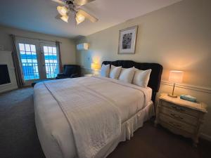 1 dormitorio con 1 cama grande con colcha blanca en The French Country Inn en Lake Geneva
