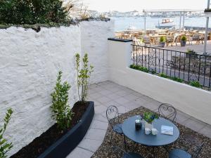 a patio with two tables and chairs and the ocean at Beachside Cottage in Shaldon