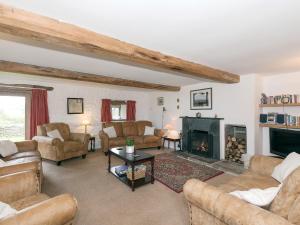 a living room with couches and a fireplace at Cowdber Barn in Cowan Bridge