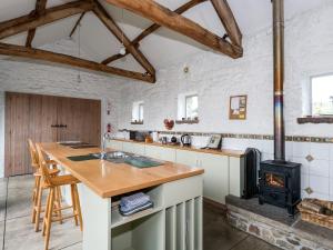 a kitchen with a wood stove in a room at Cowdber Barn in Cowan Bridge