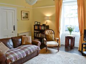 a living room with a couch and a chair and a window at The Cottage in Garlieston