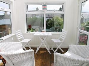 a room with chairs and a table and a window at The Cottage in Garlieston