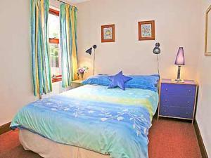 a bedroom with a blue bed with a blue star on it at 5 Milnamair in Montrose