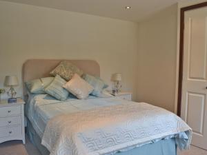 a bedroom with a bed with pillows on it at Paper Mill Cottage in Sutton