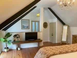 um quarto com uma cama e uma televisão num sótão em Granny Mcphees Cottage Hssh em Beaworthy