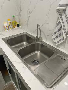 a stainless steel sink in a white kitchen at Modern Cozy 3BR Near Air-conditioned & Free Parking in Silang +14 photos