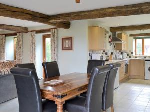 a kitchen with a wooden table and black chairs at Chive - E4326 in Ludham