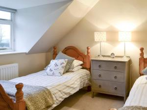 a attic bedroom with two beds and a dresser at Foulden Hill Farm Cottage in Foulden