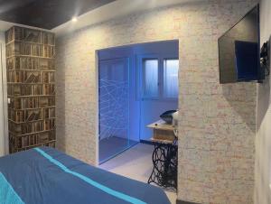 um quarto com uma porta azul e uma parede de tijolos em Butterfly By Carl-Emilie em Épinal
