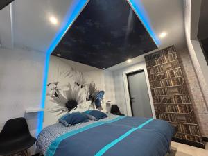una camera con un letto e un soffitto azzurro illuminato di Butterfly By Carl-Emilie a Épinal