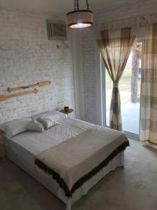 a bedroom with a large bed and a window at Chalé MAAR in Itarema