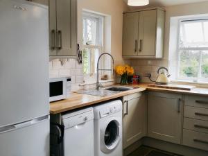 a kitchen with a washing machine and a sink at Miller Cottage in Malham
