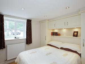 a bedroom with a bed and a window at Stable Cottage - Hw7452 in Whitford
