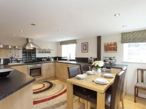 a kitchen with a wooden table and a dining room at Stable Cottage - Hw7452 in Whitford