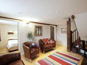 a living room with a couch and a chair and a bed at Stable Cottage - Hw7452 in Whitford