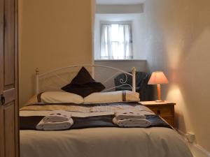 een slaapkamer met een bed met twee handdoeken erop bij Nyffryn Bella in Llandudwen