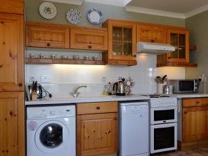 a kitchen with a washing machine and a washer at Belloch Cottage in Glenbarr
