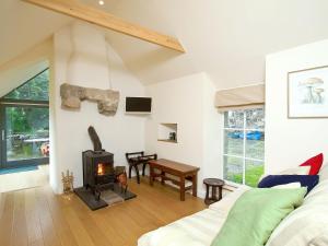 a living room with a fireplace and a stove at Tullibole Castle Longhouse in Crook of Devon