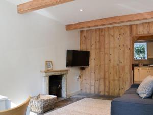 sala de estar con chimenea y TV de pantalla plana en Clarence Cottage en Appleby