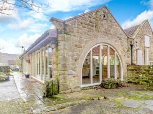 a large stone house with a large window at The Forge in Hawnby