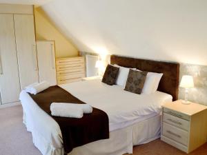 Saint CleerにあるRiverside Cottage - B6859のベッドルーム(大型ベッド1台、ナイトスタンド付)
