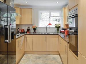 a kitchen with wooden cabinets and a sink and a window at Riverside Cottage - B6859 in Saint Cleer