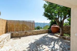 a patio with a tree and a fence at Le dimore di piazza torre in Torchiara