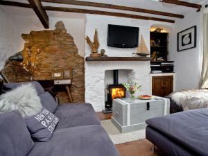 a living room with a couch and a fireplace at Fishlegs in Brixham