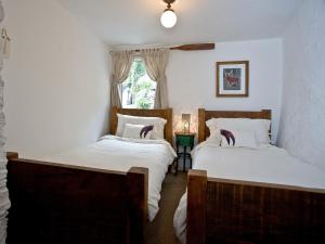 a bedroom with two beds and a window at Fishlegs in Brixham