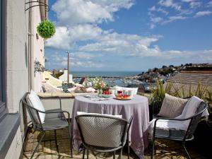 a table and chairs on a balcony with a view of the ocean at Fishlegs in Brixham