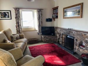 a living room with a couch and a fireplace at Borrowdale Cottage in Brough