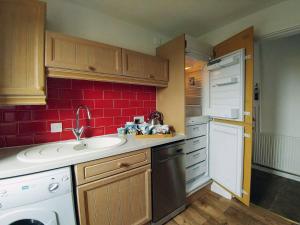 a small kitchen with a sink and red tiles at Borrowdale Cottage in Brough