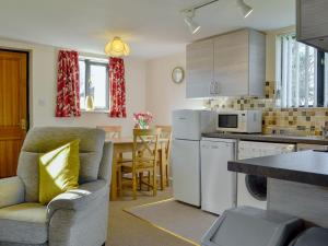 cocina con sofá y silla en una habitación en Sallys Nest - E3042 en Blyford