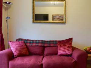 a purple couch in a living room with a mirror at St Andrews Hideaway in St. Andrews