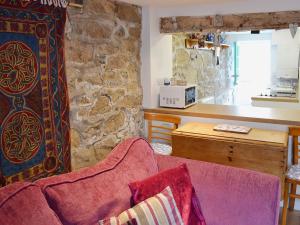 a living room with a couch and a stone wall at Driftwood in St Ives