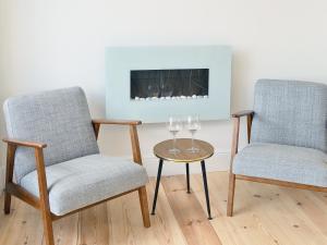 two chairs and a table with wine glasses on it at Coastguard Cottage in Chestfield