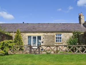 een stenen huis met een houten hek ervoor bij Snooty Fox Cottage in Hexham