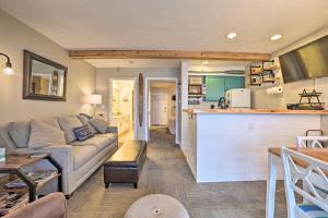 a living room with a couch and a kitchen at Updated Onekama Resort Condo on Portage Lake! in Onekama