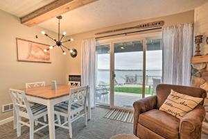a dining room with a table and chairs and a view of the ocean at Updated Onekama Resort Condo on Portage Lake! in Onekama